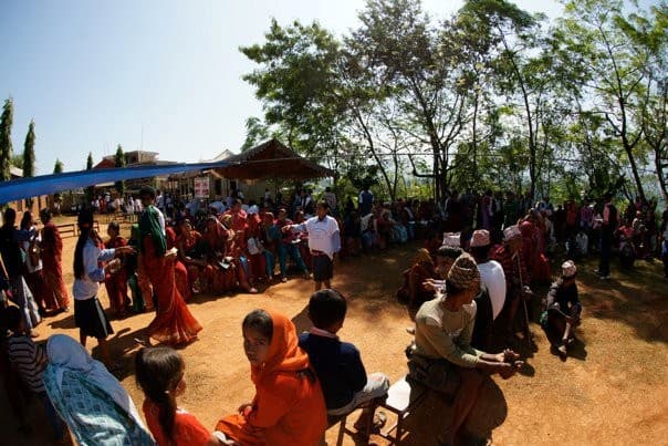 A whole village gathered under a tree at a C4GC medical camp